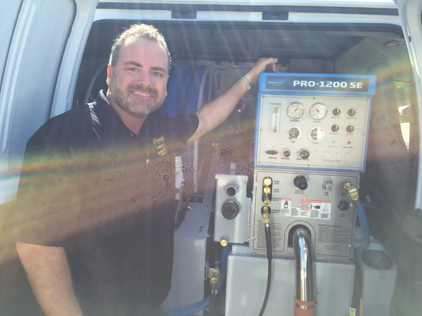 A man standing in the back of a truck next to an air compressor.