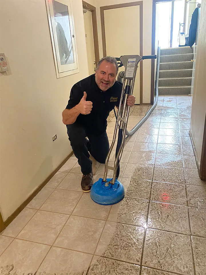 A man is standing in front of a tile floor.