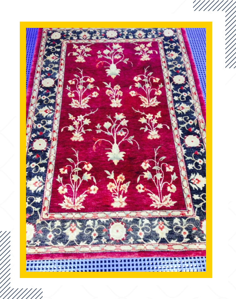 A red rug with black and white floral design.