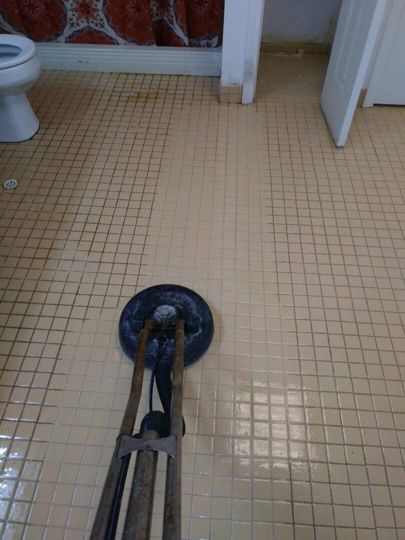 A floor cleaner is being used to clean the bathroom.