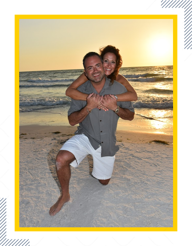 A man and woman are hugging on the beach.